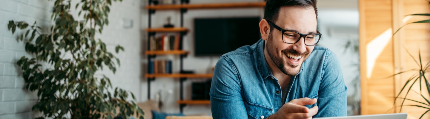 A smiling man looking at computer